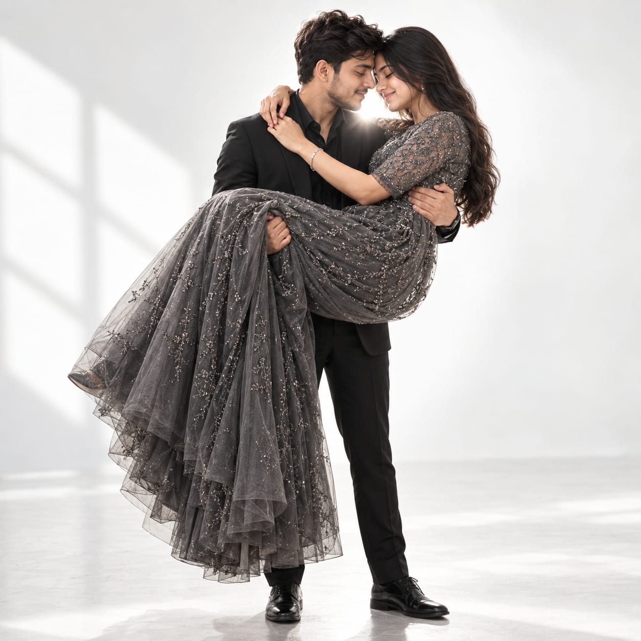 Romantic couple with a bearded man in a black suit carrying a woman in a sparkling dark-gray evening gown against a bright white studio background